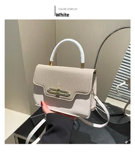 Detail of white square crossbody bag with textured flap, round handle and gold buckle