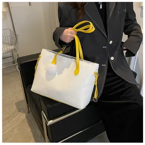 Détail du cabas blanc gaufré avec anses jaunes et pendentif en forme de cœur mignon