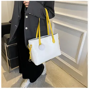 Gros plan du sac cabas blanc gaufré avec motifs floraux et bandoulière jaune vif