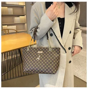 Detalle de bolso tote marrón con diseño de estrellas, colgante de ciervo y correa de cadena