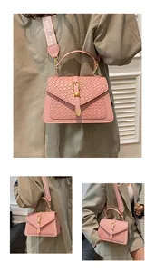 Detail of pink woven texture crossbody bag with metal buckle and patterned wide strap