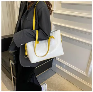Détail du sac cabas blanc gaufré avec accents jaunes et pompon en peluche doux