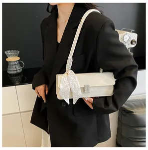 Detail van minimalistische beige handtas met zilveren gesp en hartjes zijden sjaal