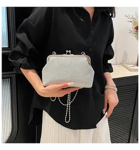 Detail of silver glitter evening clutch bag with metal frame and delicate pearl chain strap