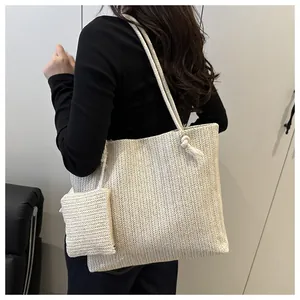 Detail van beige rieten shopper met visgraattextuur en handvaten van touw