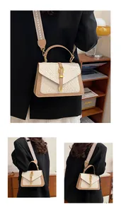 Detail of woven cream flap with brown leather base and golden metallic clasp closure