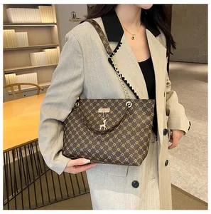 Vista detallada del bolso tote vintage con monograma y colgante de ciervo dorado