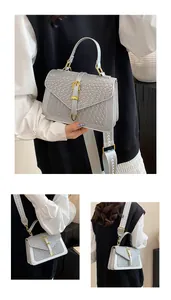 Detail view of woven leather texture on light grey handbag with golden horse-buckle accent