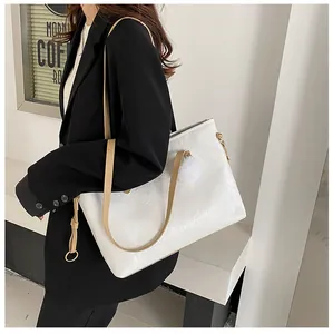Détail du sac cabas en cuir gaufré blanc avec motifs de dessins animés et breloque peluche