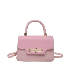 Pink patchwork crossbody bag with textured fabric flap and golden clasp fastener