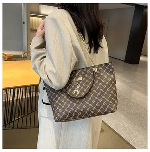 Primer plano del bolso tote vintage con correa de cadena dorada y colgante de ciervo