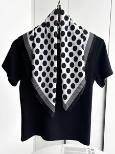 Polka dot silk scarf layered on a black t-shirt showing stylish neckwear styling