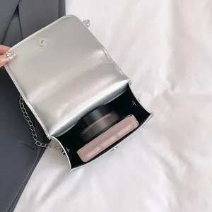 Mini sac carré argenté avec bandoulière chaîne montrant la capacité intérieure