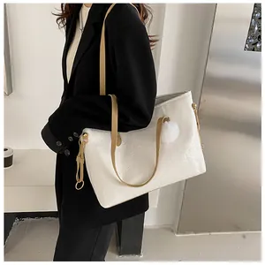 Détail du sac fourre-tout blanc gaufré avec motifs cartoon, anses brunes et pompon peluche