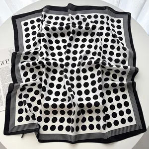 Detailed flat lay of a silk-feel square scarf featuring classic black and white polka dots