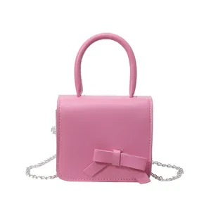 Mini sac carré rose avec nœud contrasté et bandoulière en chaîne argentée