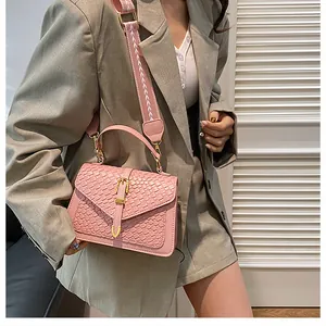 Detailed pink crossbody bag with woven texture and embroidered shoulder strap detail
