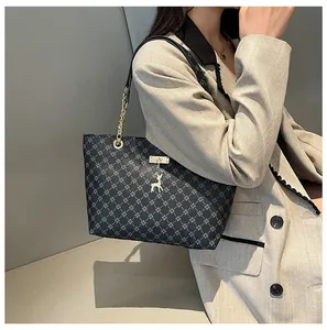 Detalle del bolso tote vintage con patrón de estrellas, colgante de ciervo y cadena