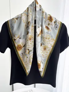 Dettaglio di foulard in seta con fiori e api, drappeggiato su una maglietta nera chic