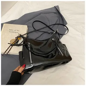 Glänzende schwarze Lackleder-Tasche mit doppelten Reißverschlüssen und Tennis-Anhänger