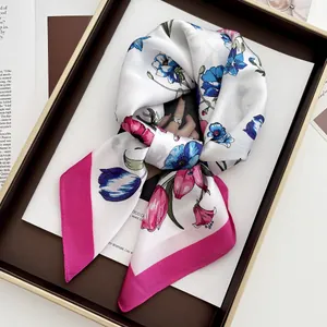 Detail view of a floral silk scarf with pink edges displayed on an aesthetic magazine
