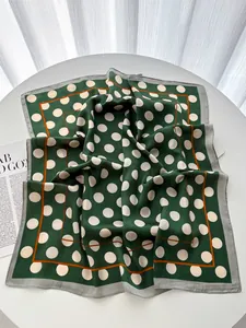 Detail of green square silk scarf with white polka dots and elegant orange edge trim