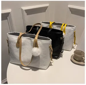 Détails des motifs gaufrés sur trois grands sacs cabas en cuir PU avec pompons en fourrure