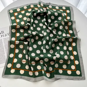Detail of vintage dark green polka dot silk scarf with elegant orange and grey borders