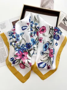Detail of silk-feel scarf with floral butterfly print and mustard yellow border