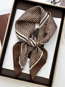 Macro shot of silk square scarf featuring geometric pattern and elegant chain design