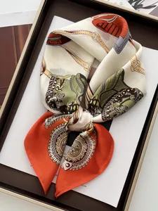 Detail of luxury silk scarf with chain horsebit pattern in elegant gift box packaging