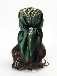 Close-up of dark green satin scarf with vintage paisley print worn as a headscarf