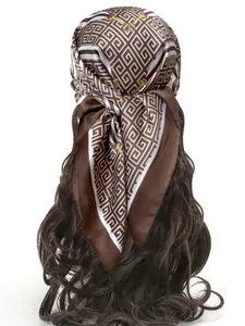Detail of silk scarf with greek key pattern and gold chain motifs tied in hair
