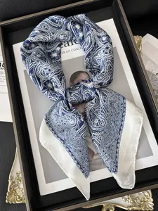 Close-up of blue and white paisley silk scarf with satin finish on elegant background