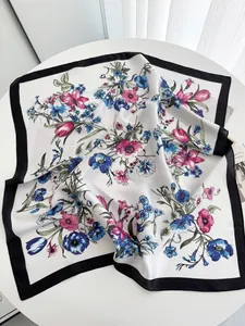 Detail of silk square scarf showing pink floral tulip patterns and wide black borders