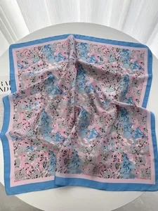 Close-up of silky floral square scarf with elegant pink and blue watercolor patterns