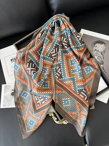 Detailed close-up of silk-like square scarf featuring geometric pixel grid patterns
