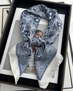 Detail of blue and white paisley silk scarf folded elegantly on a fashion magazine