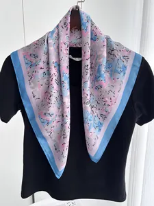 Detailed drape of a pastel floral silk square scarf on a black t-shirt for daily styling