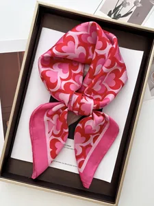 Close-up of red heart pattern silk scarf tied in a bow on a luxury display tray