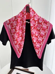 Detail of red and pink heart pattern satin scarf styled on a black cotton t-shirt