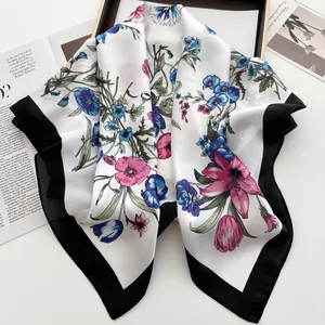 Close-up of floral print silk scarf with black border on a fashion magazine