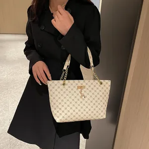 Bolso tote crema clásico con estampado de tréboles y colgante de ciervo dorado