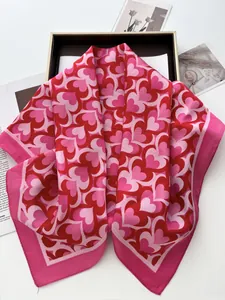 Close-up of red heart pattern silk scarf with premium geometric design and hemmed edges