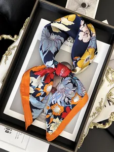Gros plan d'un foulard en satin bleu foncé avec imprimé floral noué en nœud élégant