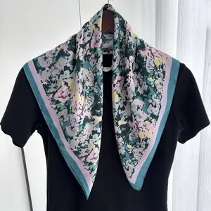 Detail of square silk scarf with abstract floral patterns and pink striped borders