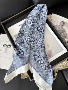 Macro shot of silk satin scarf featuring navy paisley pattern and white borders