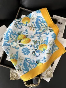 Detail showing smooth silk texture of fruit print scarf with lemon and floral patterns
