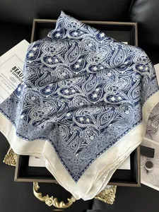 Detailed top view of blue and white paisley silk scarf in a vintage tray setting