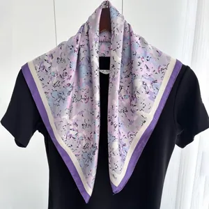 Detail of silk-like square scarf with purple floral patterns and dual-tone borders